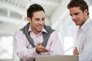 Two businessmen having discussion in front of computer --- Image by © Lava/beyond/Corbis